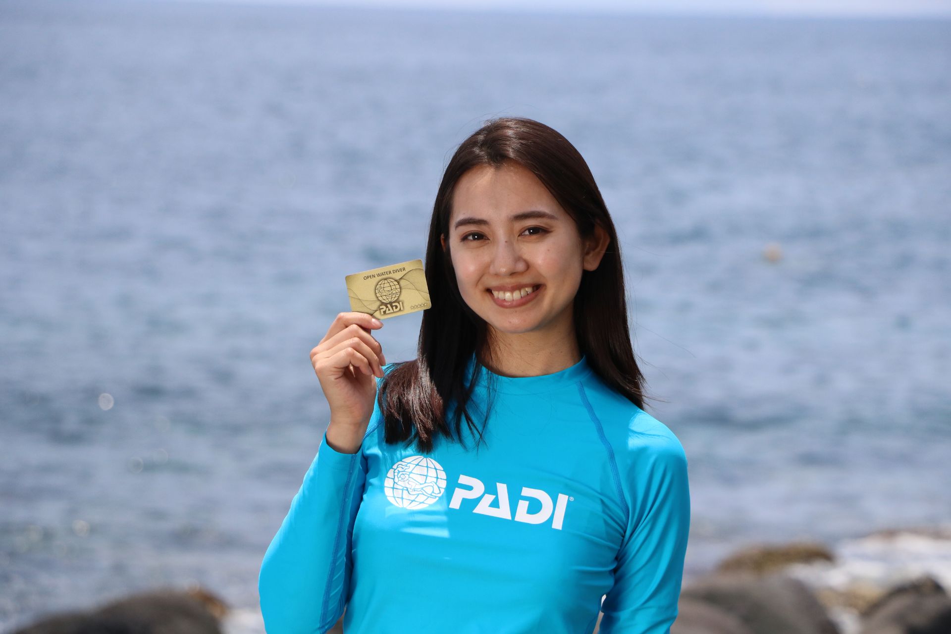 PADIダイビングライセンス認定カードを持つ女性